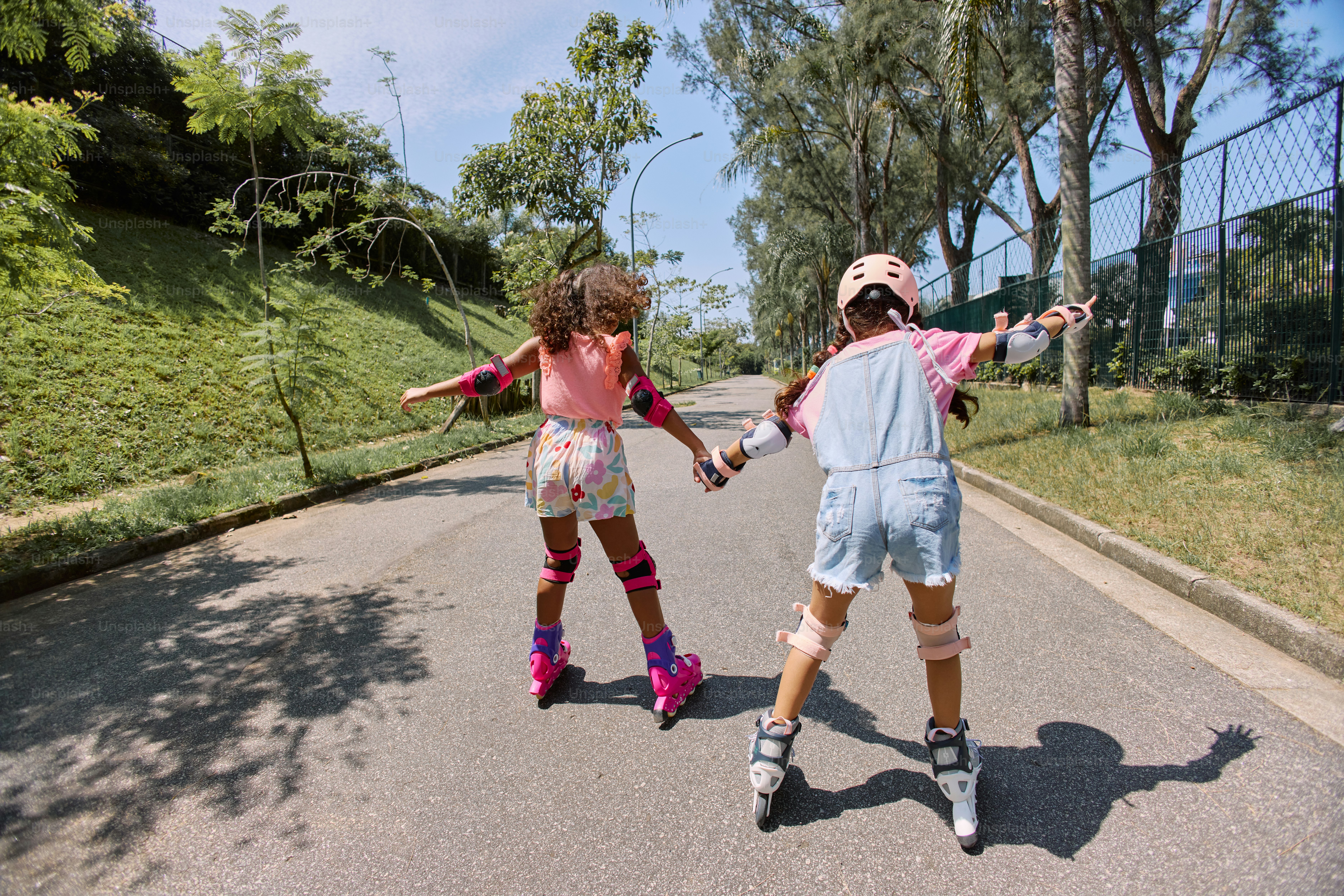 a couple of kids riding skateboards down a street