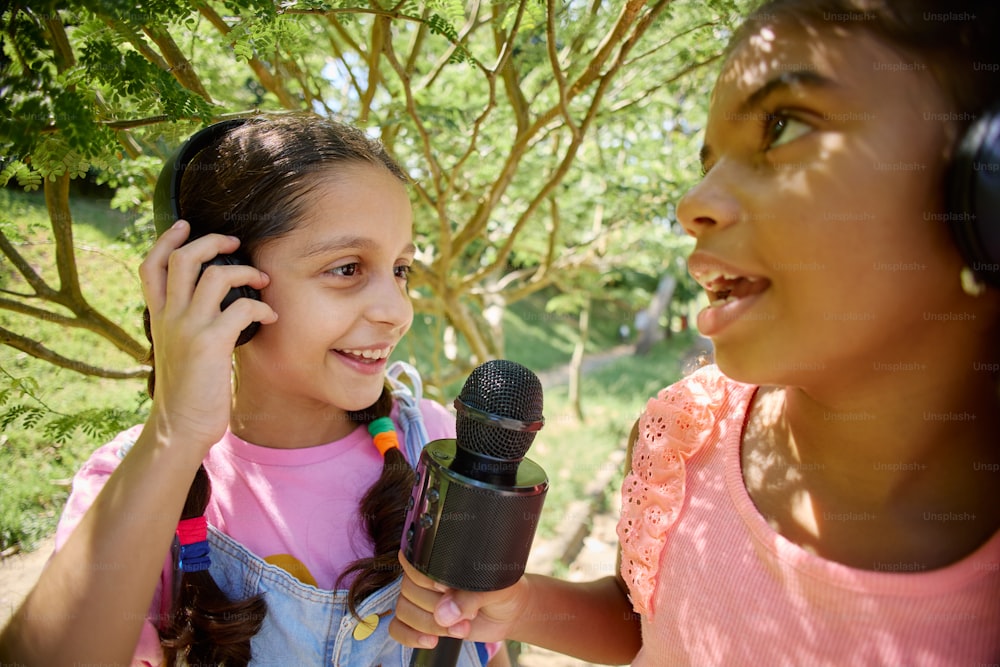 a young girl holding a microphone next to a young girl