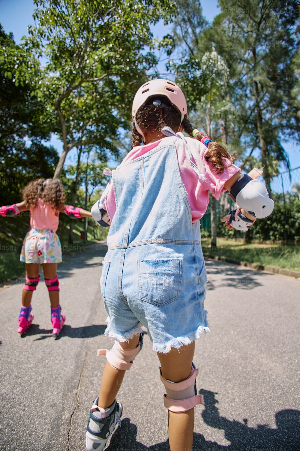 a young girl riding a skateboard down a street