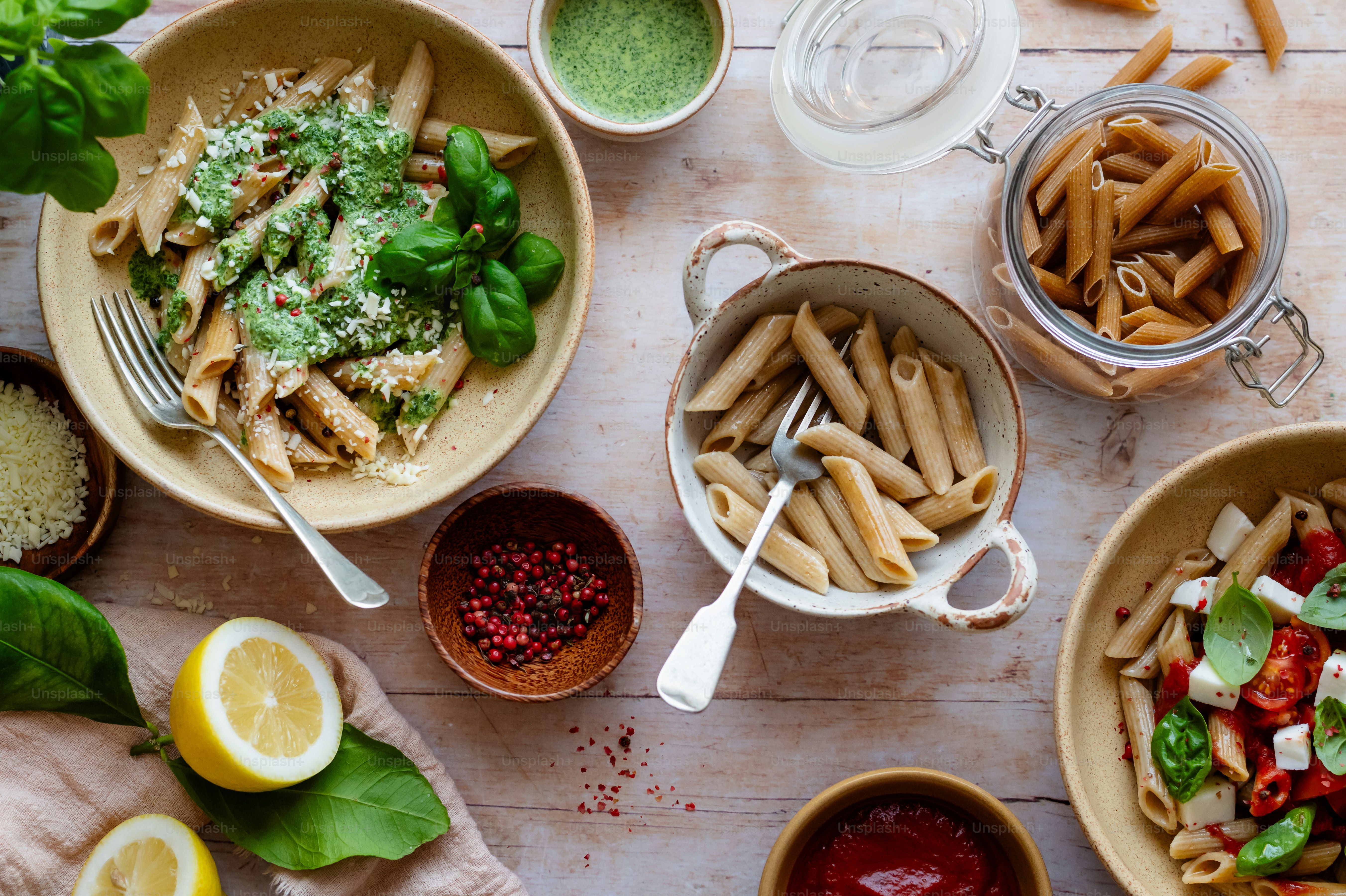 a table topped with bowls filled with pasta and veggies