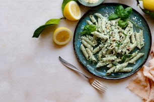 a plate of pasta with pesto and lemons