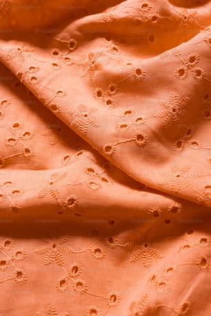 a close up of an orange fabric with small dots