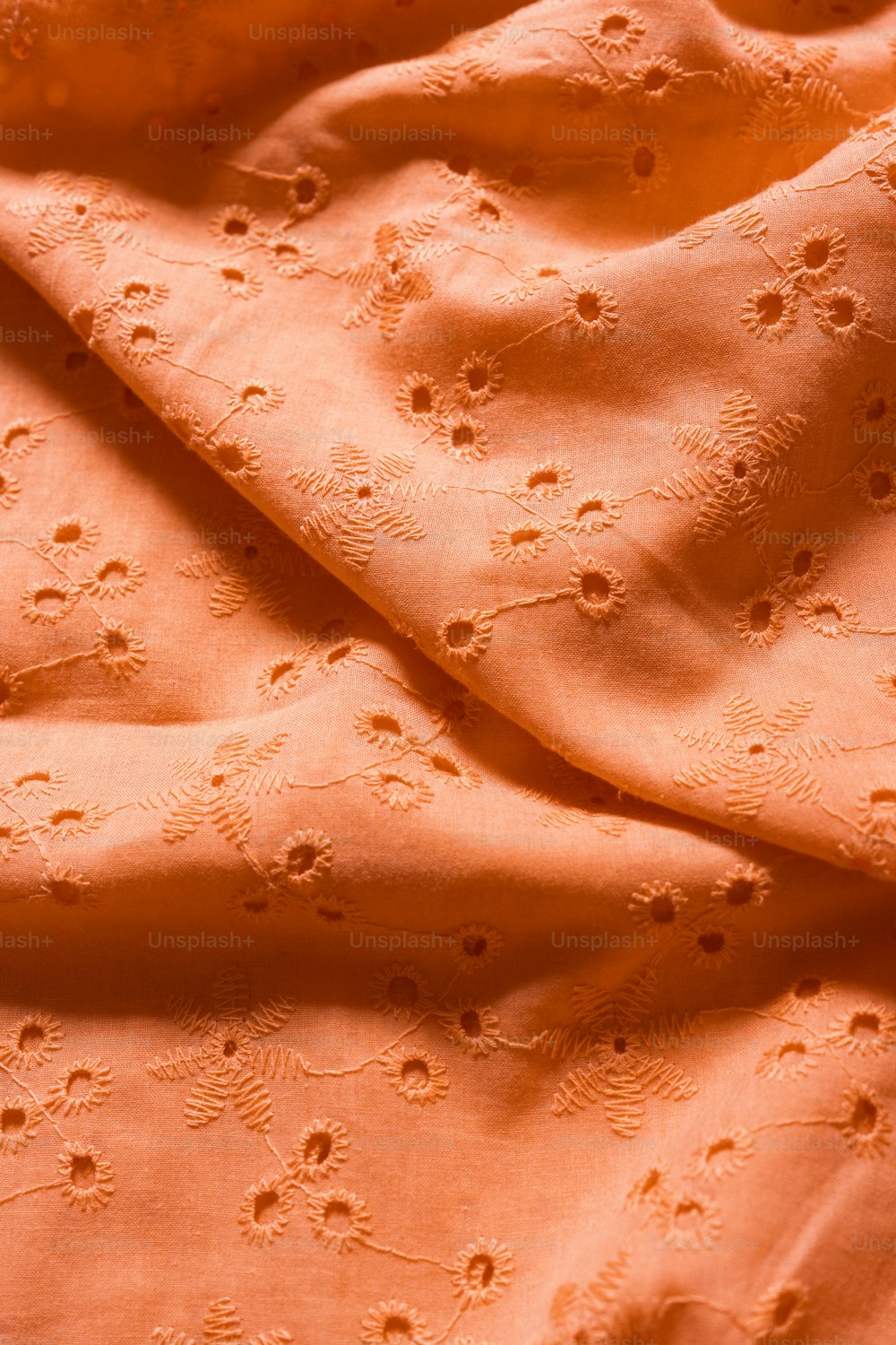 Un primer plano de una tela naranja con pequeños puntos