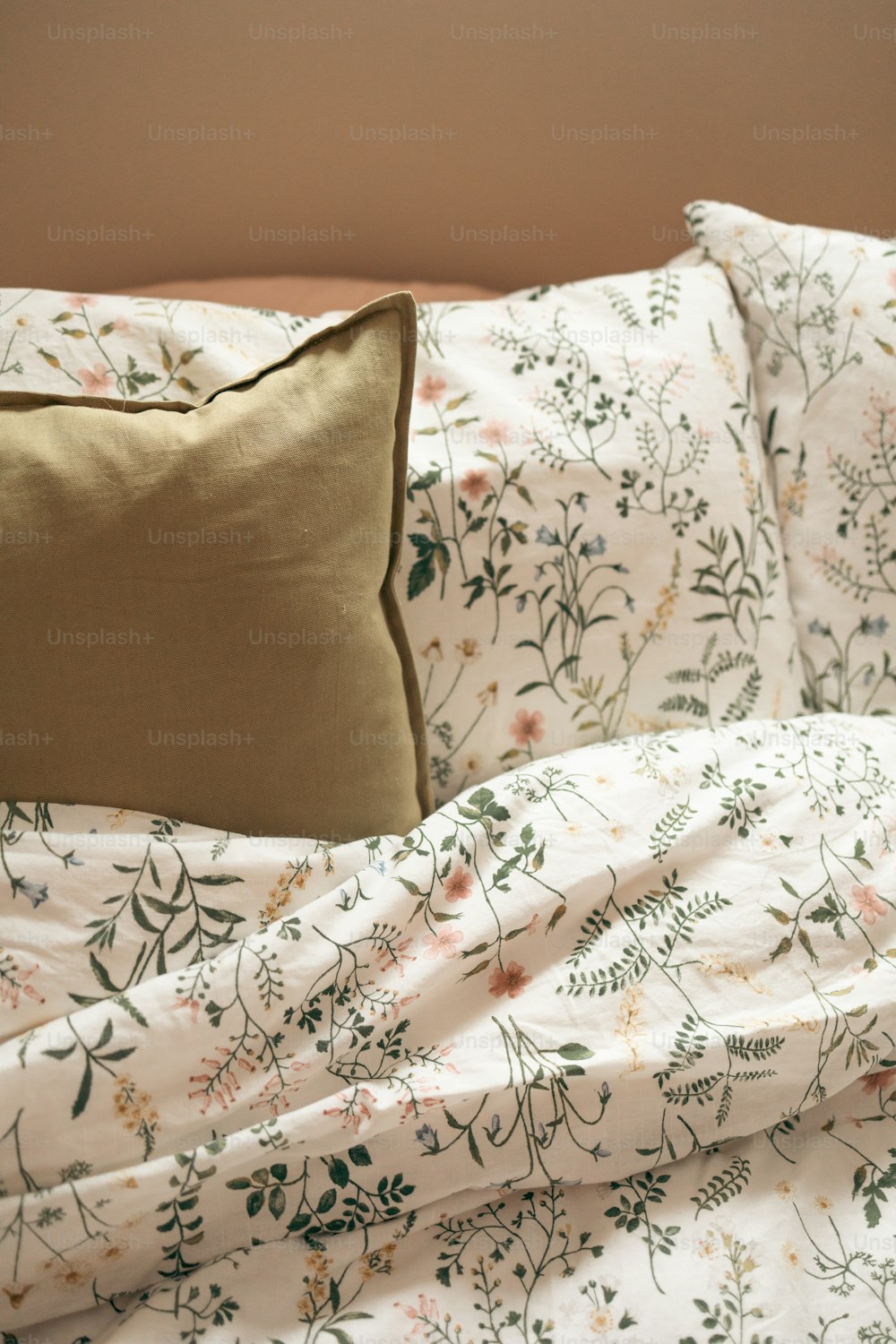 a bed with a floral comforter and a pillow