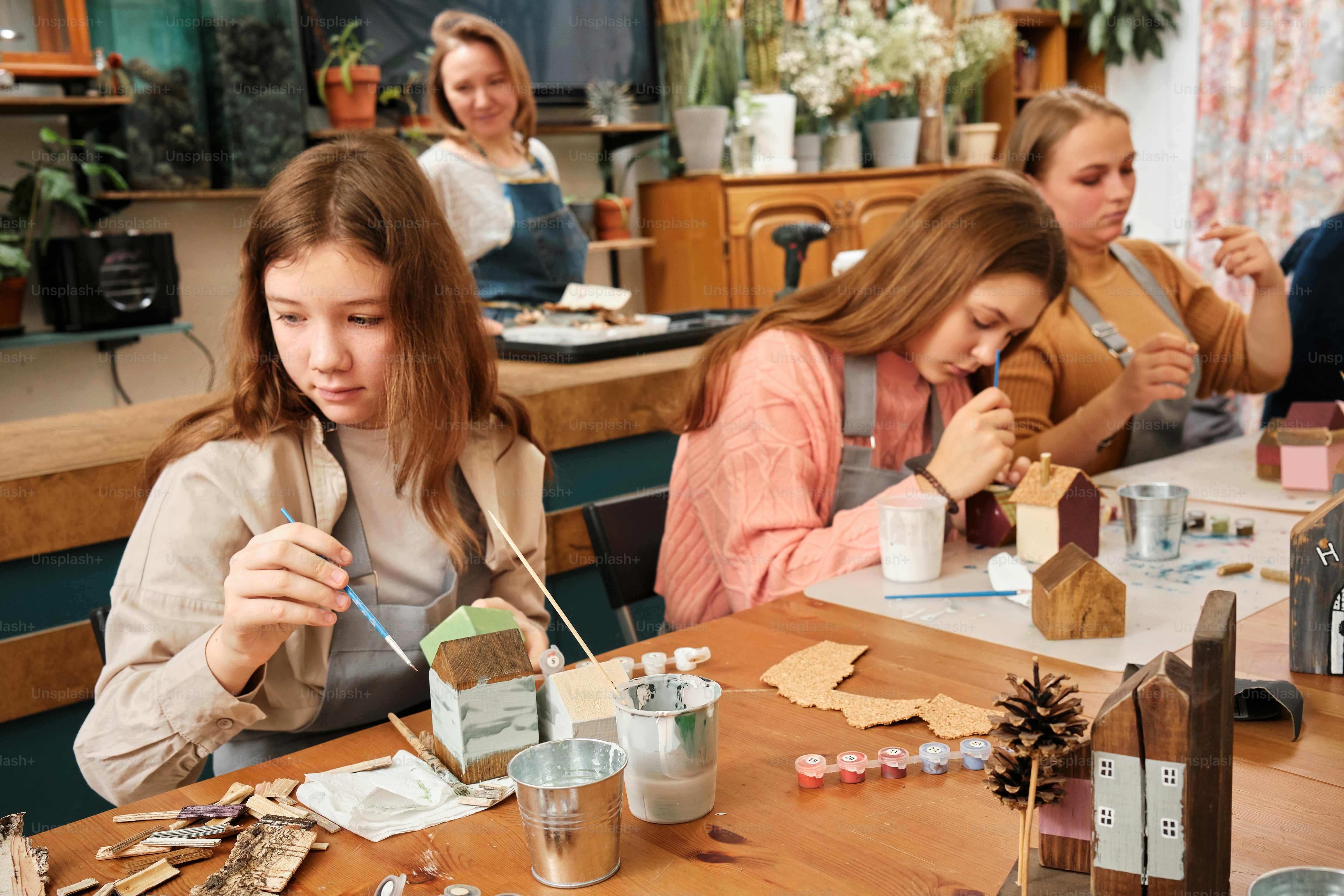 a group of women sitting at a table working on crafts