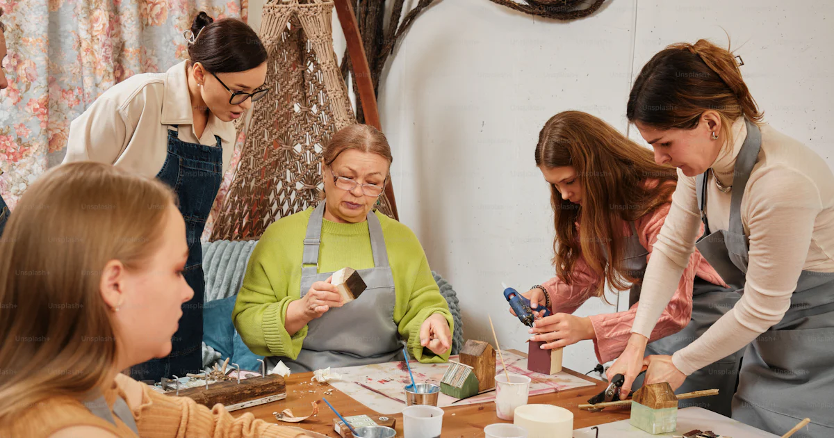 A group of women working on crafts at a table photo – Art class Image ...