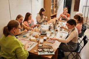 eine Gruppe von Frauen, die zusammen um einen Tisch sitzen