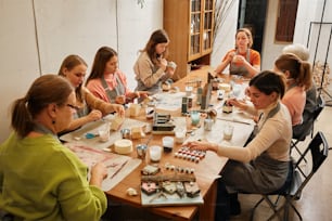 a group of women sitting around a table together