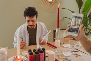 a man sitting at a table looking at a cell phone