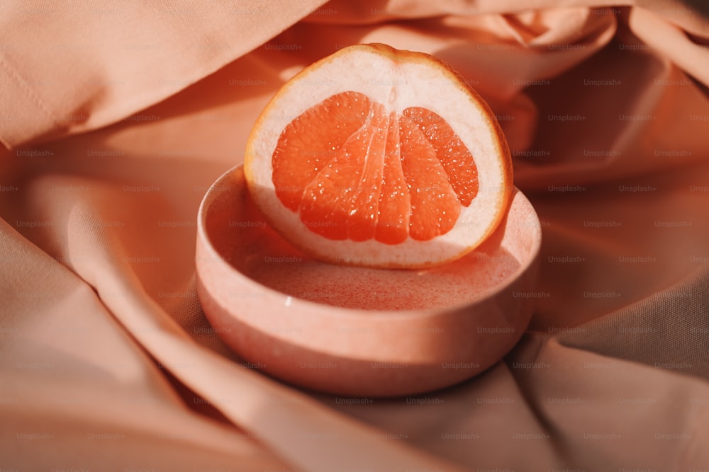 an orange cut in half sitting in a bowl
