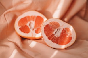an orange cut in half sitting on a cloth