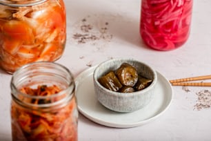 a white plate topped with pickles next to a jar of pickles