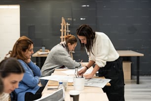 a group of women sitting at a table working on a project