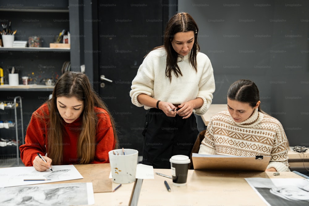 three women sitting at a table working on a project
