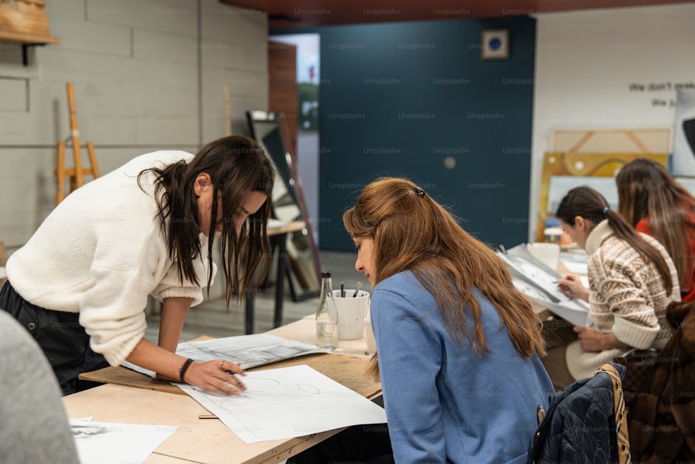 Un grupo de mujeres sentadas en una mesa trabajando en un proyecto