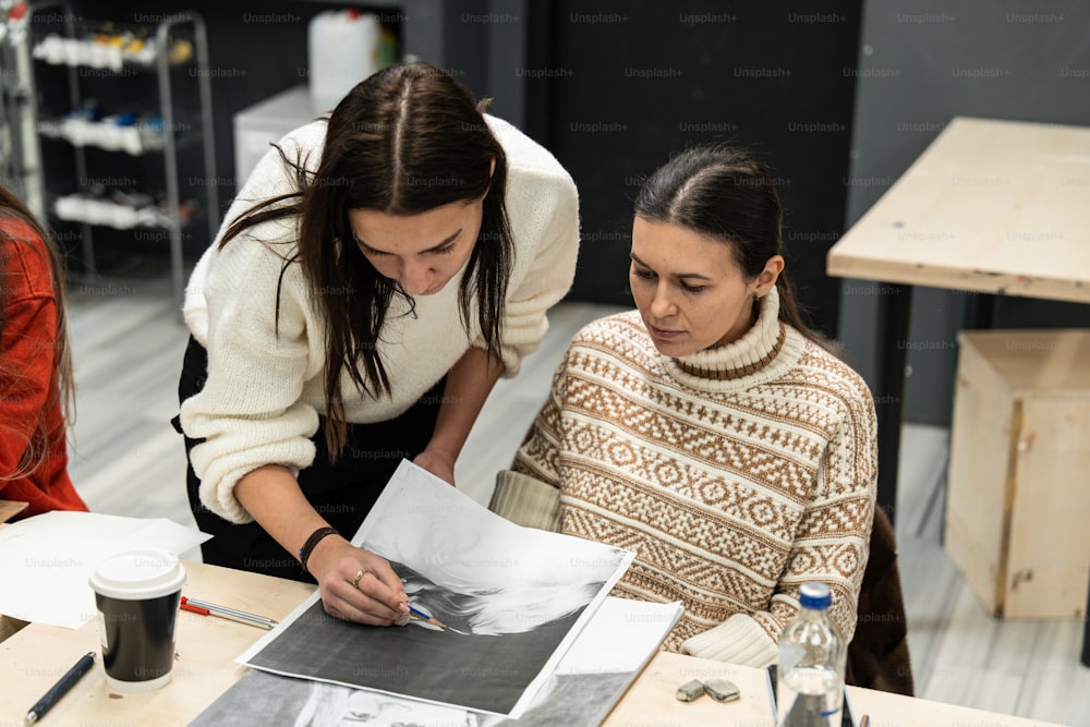 two women looking at a piece of paper on a table