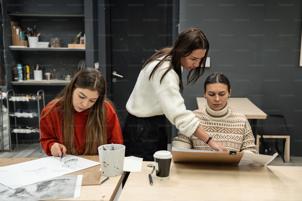 three women sitting at a table working on a project