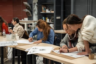 un gruppo di persone sedute a un tavolo che lavorano su disegni