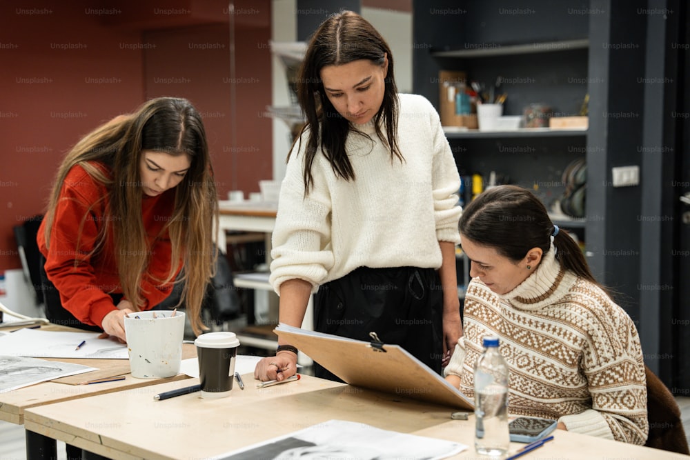 zwei Frauen, die an einem Tisch an einem Projekt arbeiten