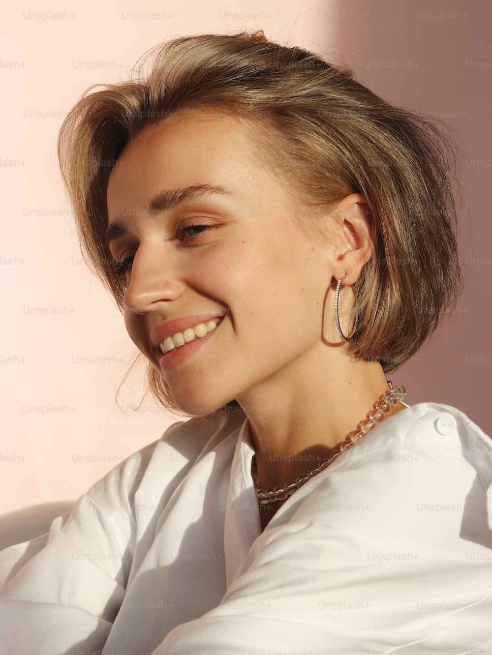 a woman wearing large hoop earrings and a white shirt