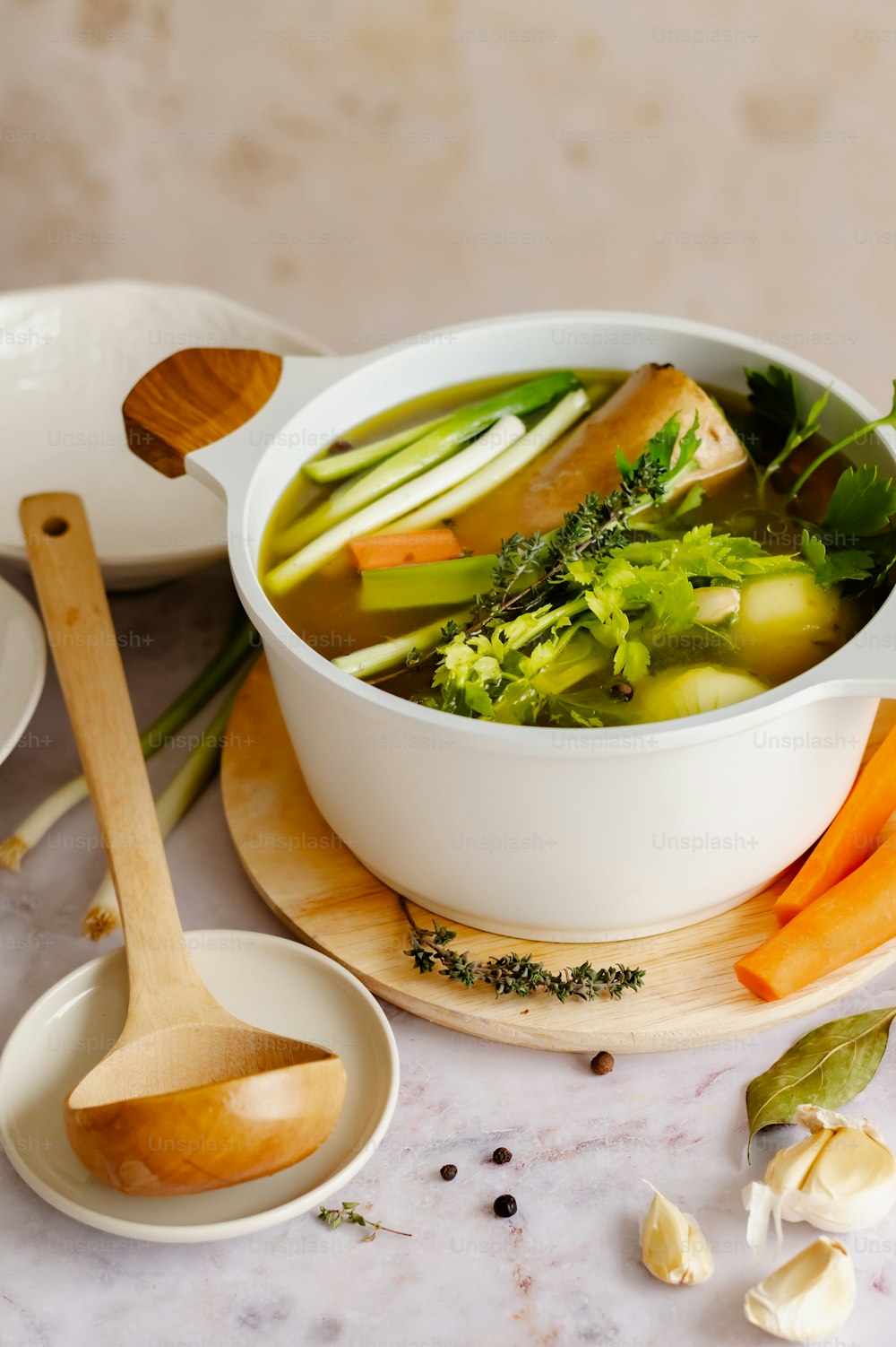 a bowl of soup with broccoli, carrots, celery,