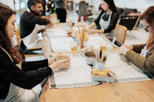 un gruppo di persone sedute intorno a un tavolo che mangiano cibo