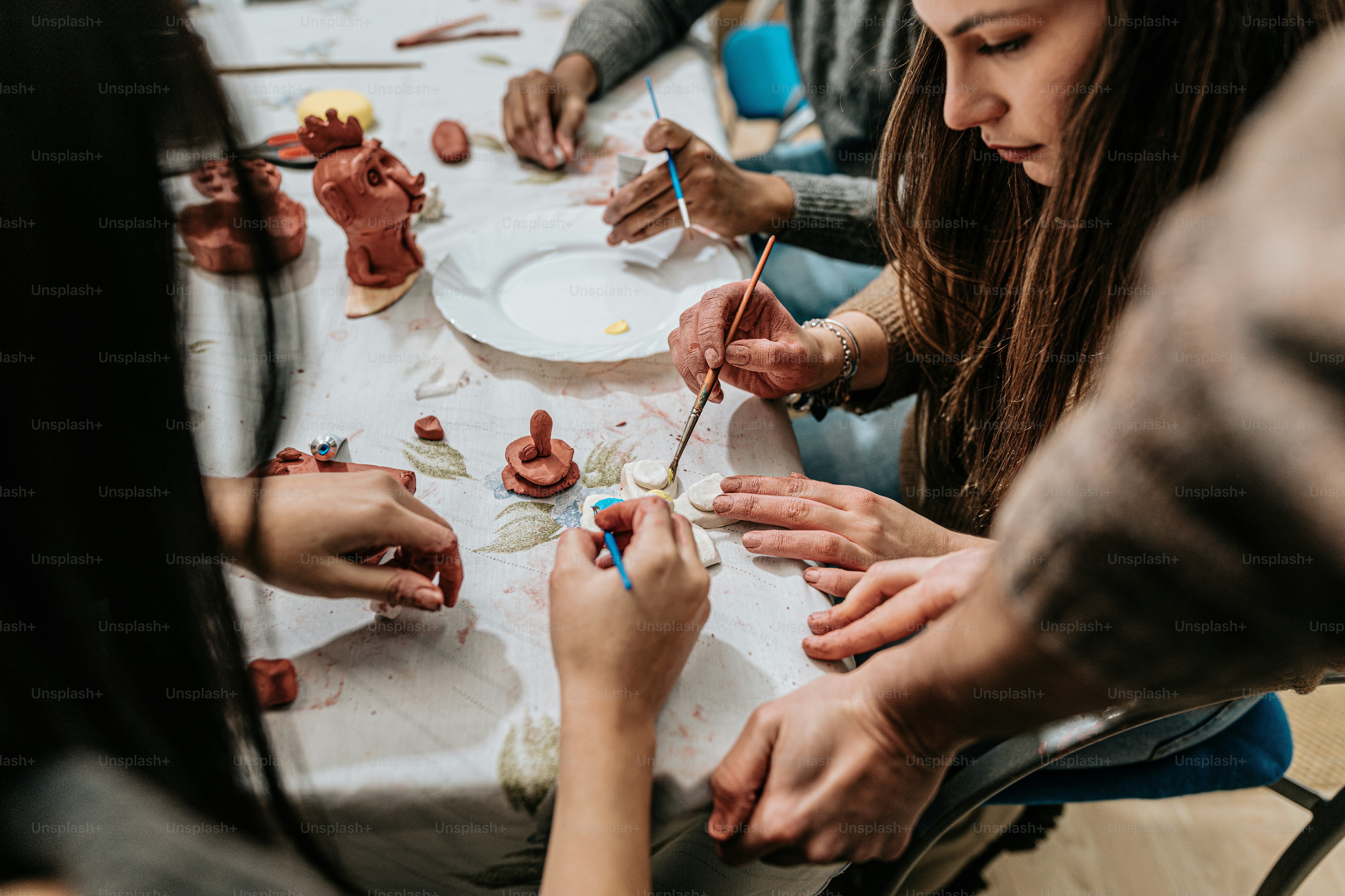 a group of people sitting around a table working on crafts