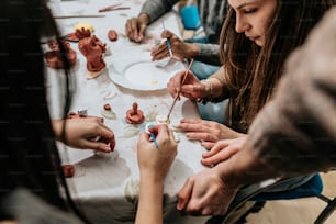 Un grupo de personas sentadas alrededor de una mesa trabajando en artesanías
