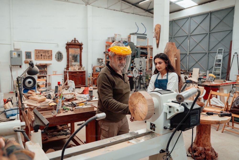 a man and a woman working on a piece of wood