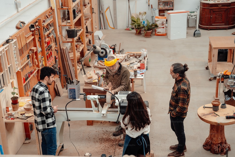 a group of people standing around a workbench
