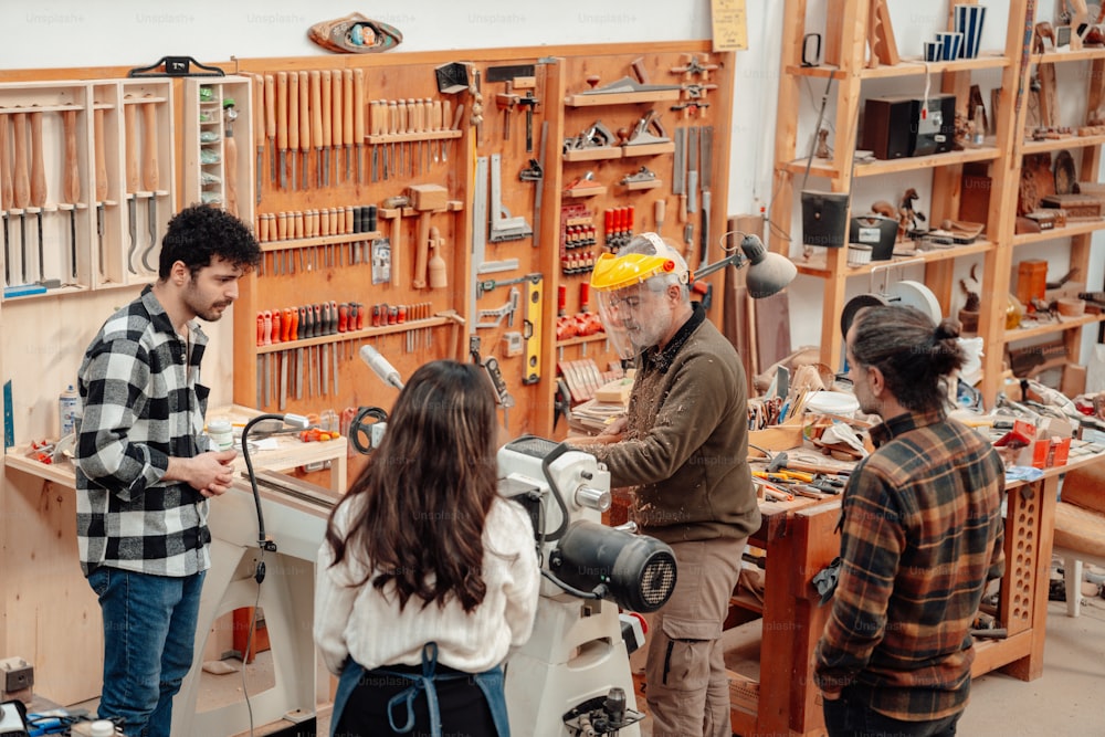 a group of people standing around a workbench