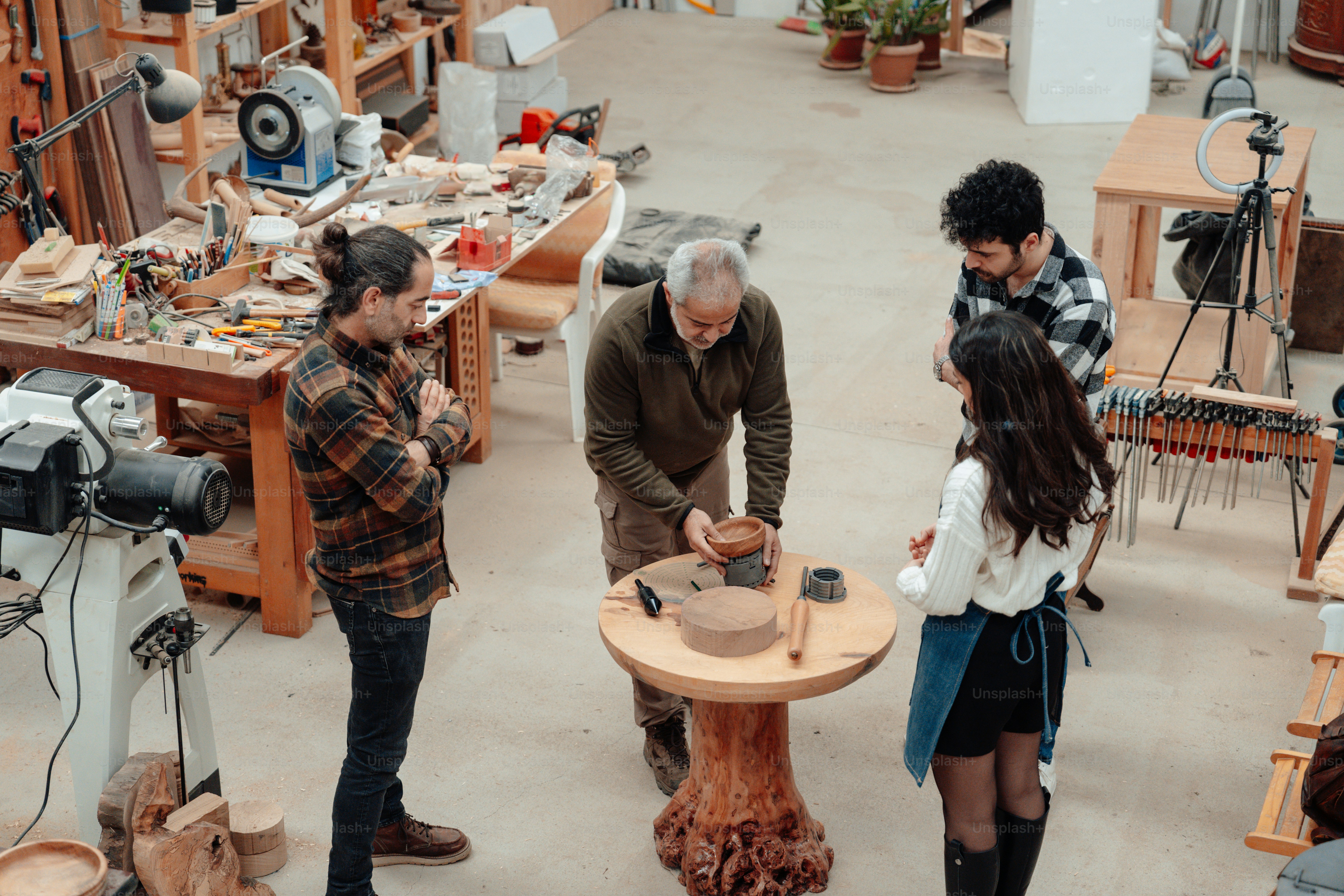 a group of people standing around a wooden table