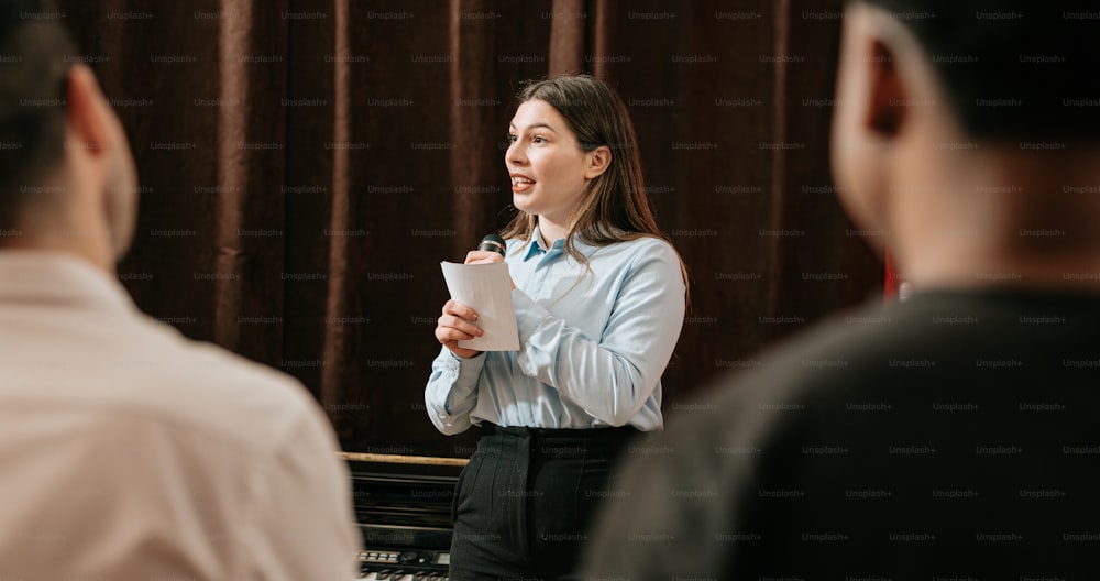 a woman standing in front of a piano holding a piece of paper