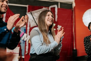 a group of people standing around each other clapping