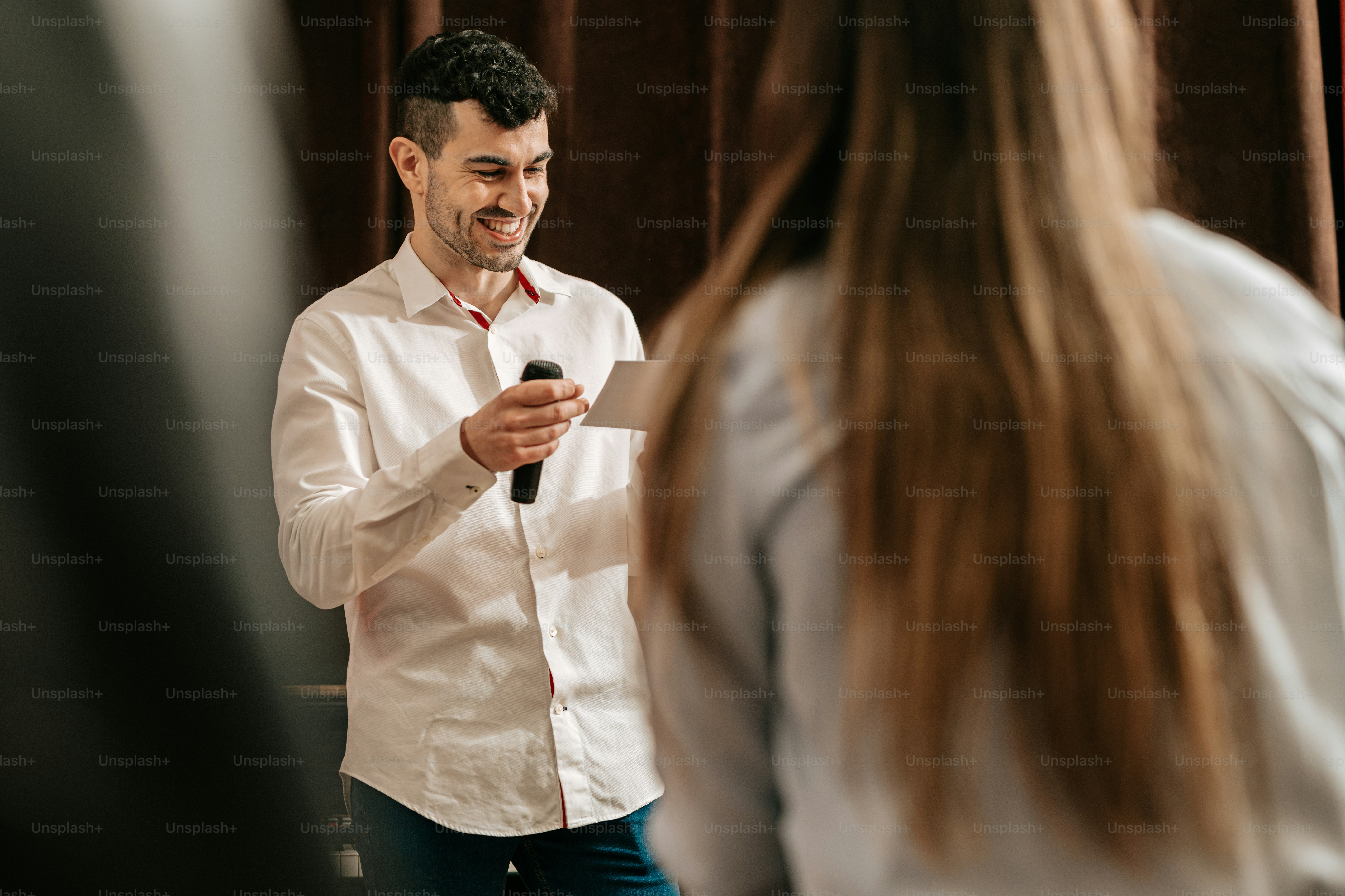 a man standing in front of a woman holding a microphone