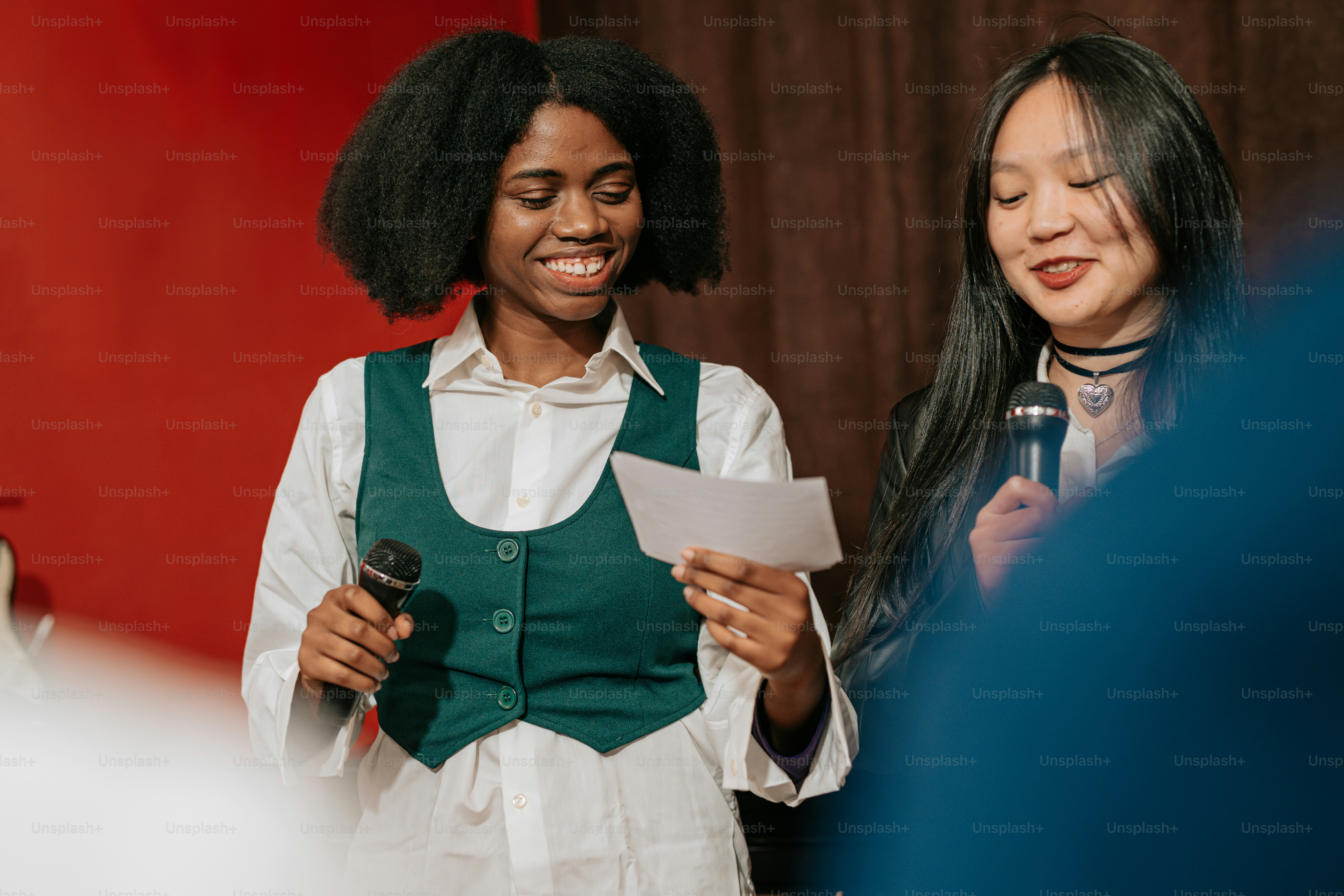 a woman standing next to a woman holding a piece of paper