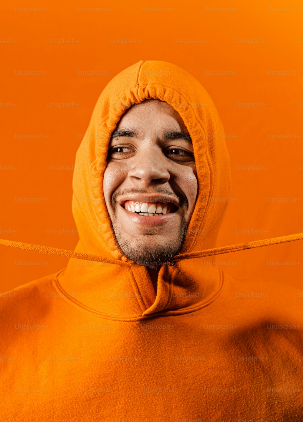 a man in a hoodie smiling for the camera