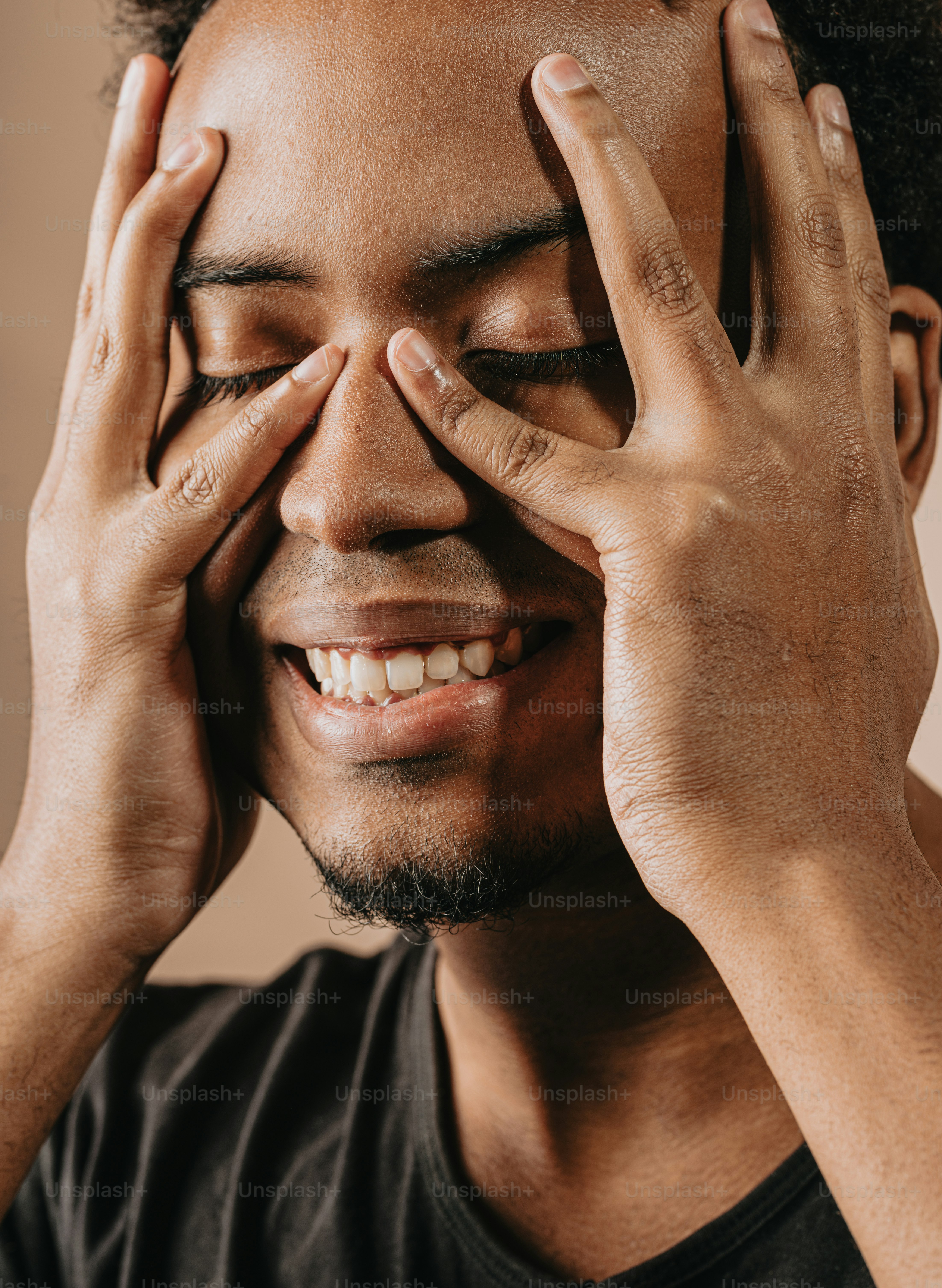 un homme portant ses mains à son visage