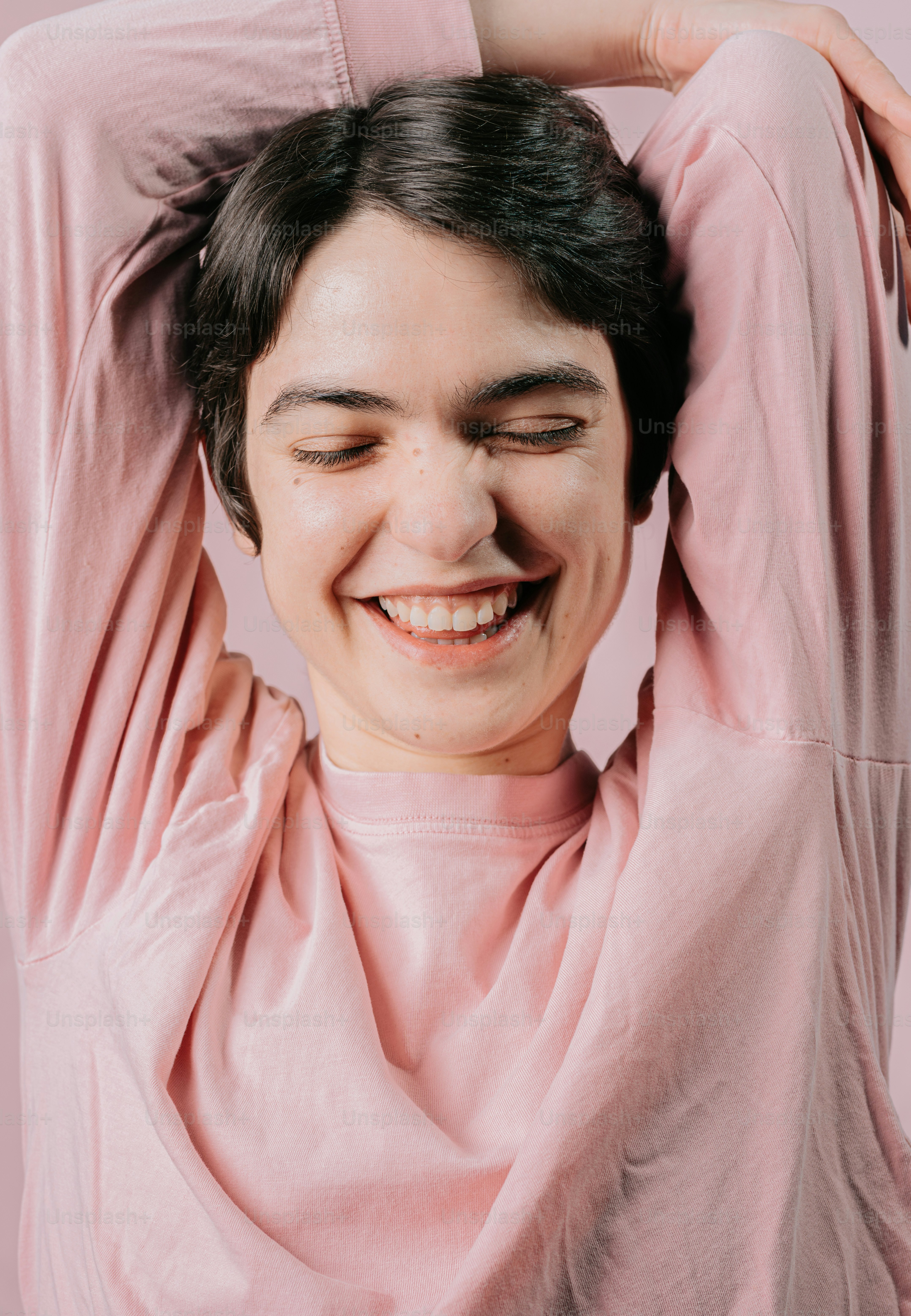 una donna con le mani sulla testa che sorride