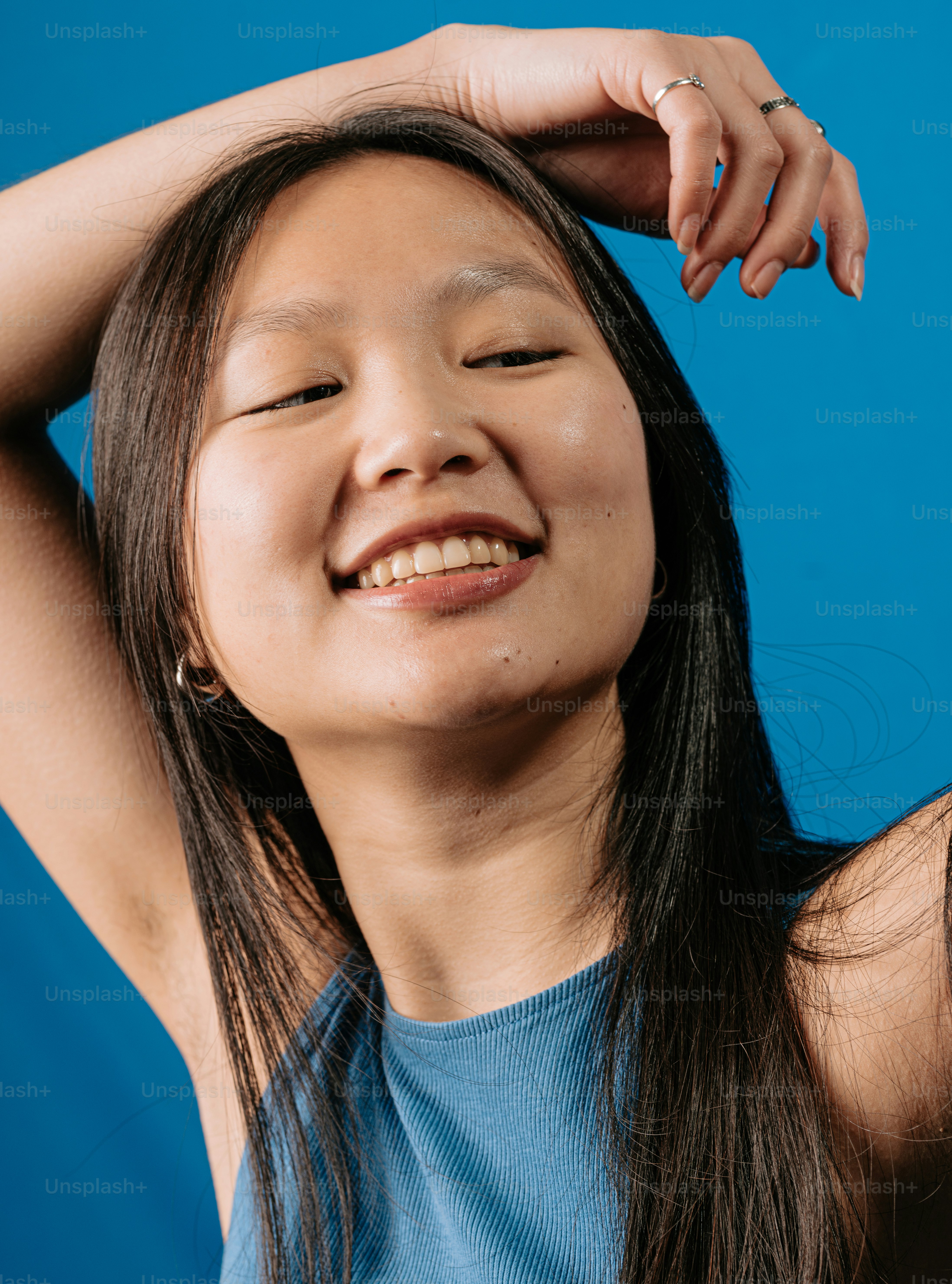 una donna che sorride e si tiene i capelli tra le mani