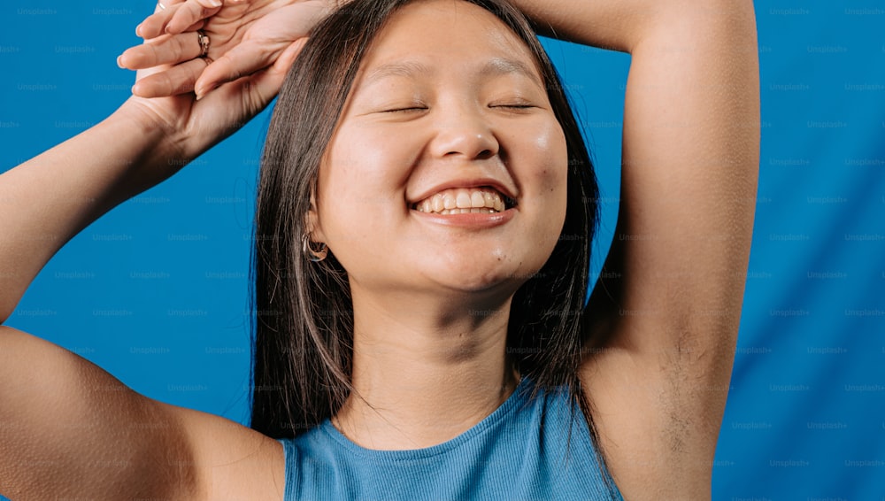 a young girl is smiling and holding her hands behind her head