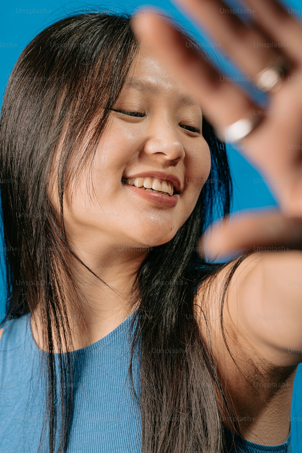 a woman smiling and holding a cell phone to her ear