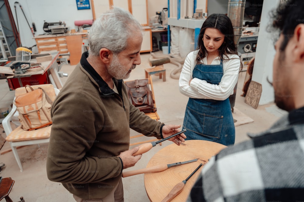 a man and a woman working on a piece of wood