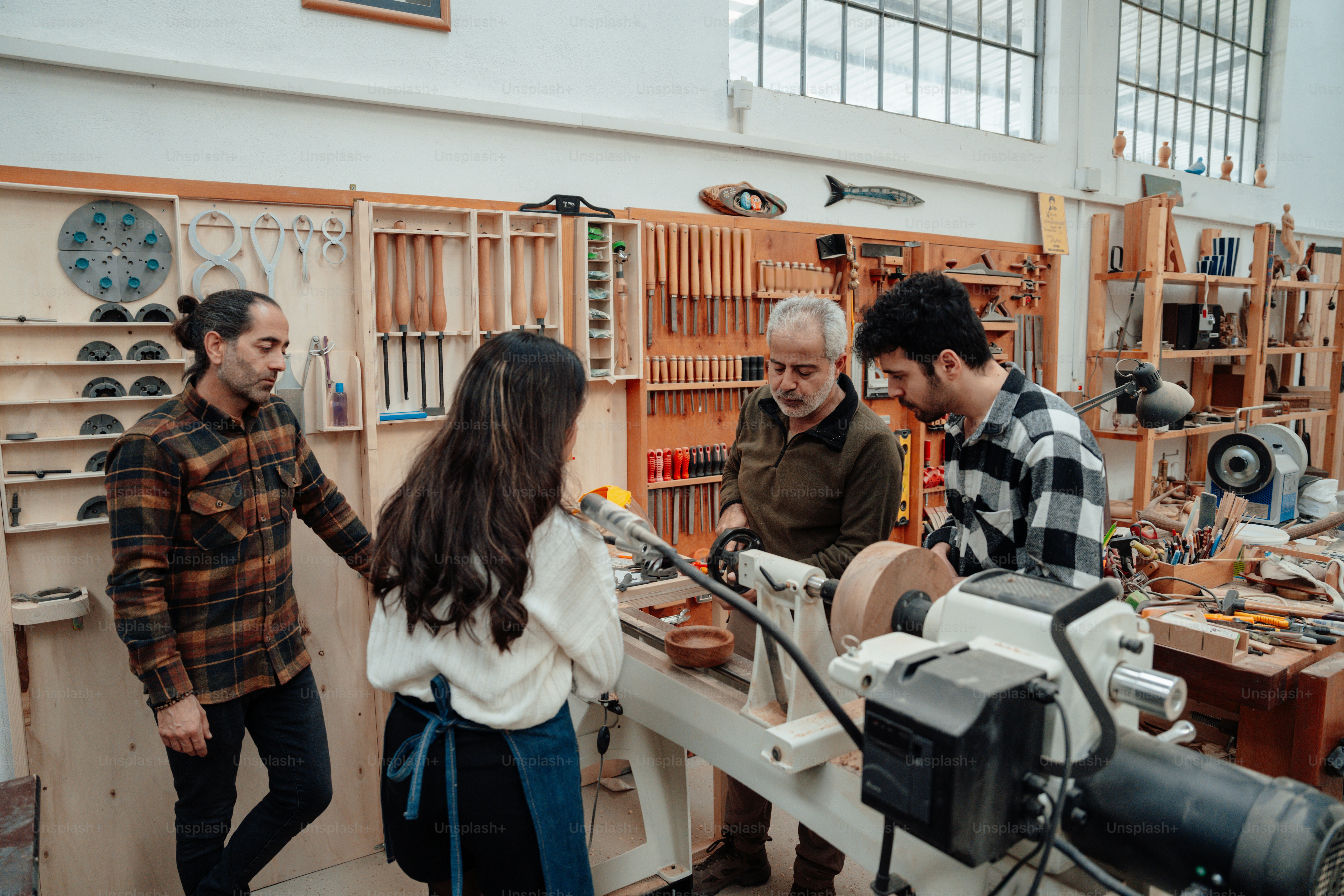 A group of people standing around a machine photo – Community Image on ...