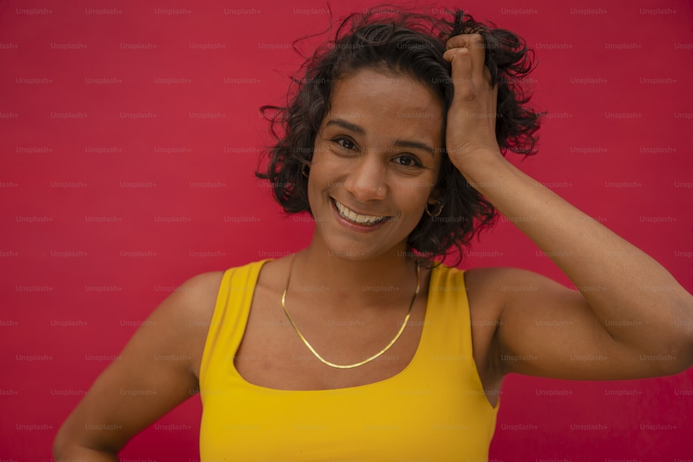 a woman in a yellow tank top is smiling