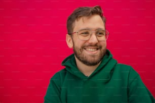 a man wearing glasses and a green hoodie