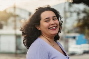 a woman with curly hair smiling at the camera