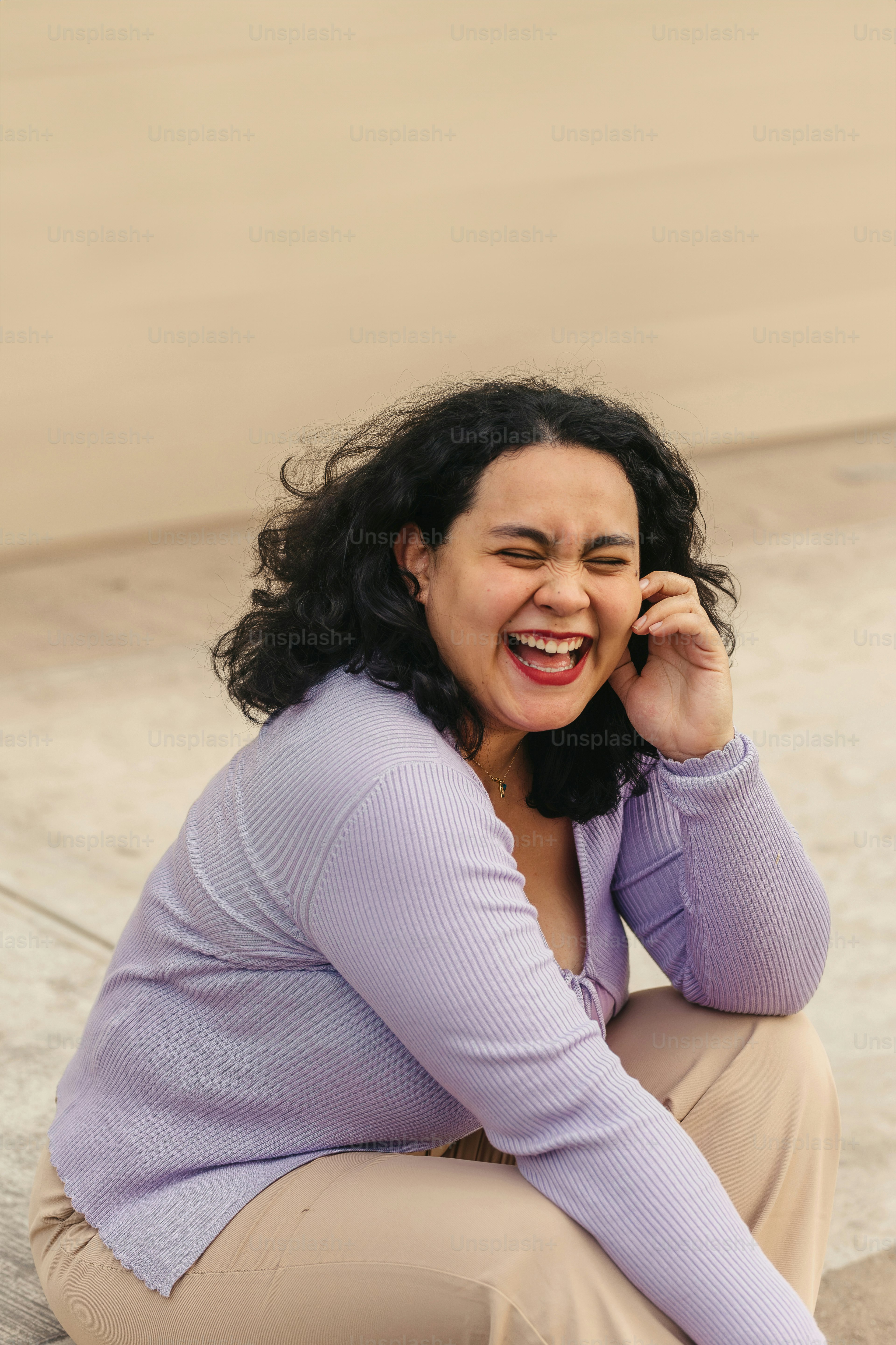 una donna seduta a terra che parla al cellulare