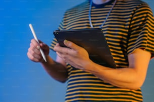 a man in a striped shirt is holding a tablet