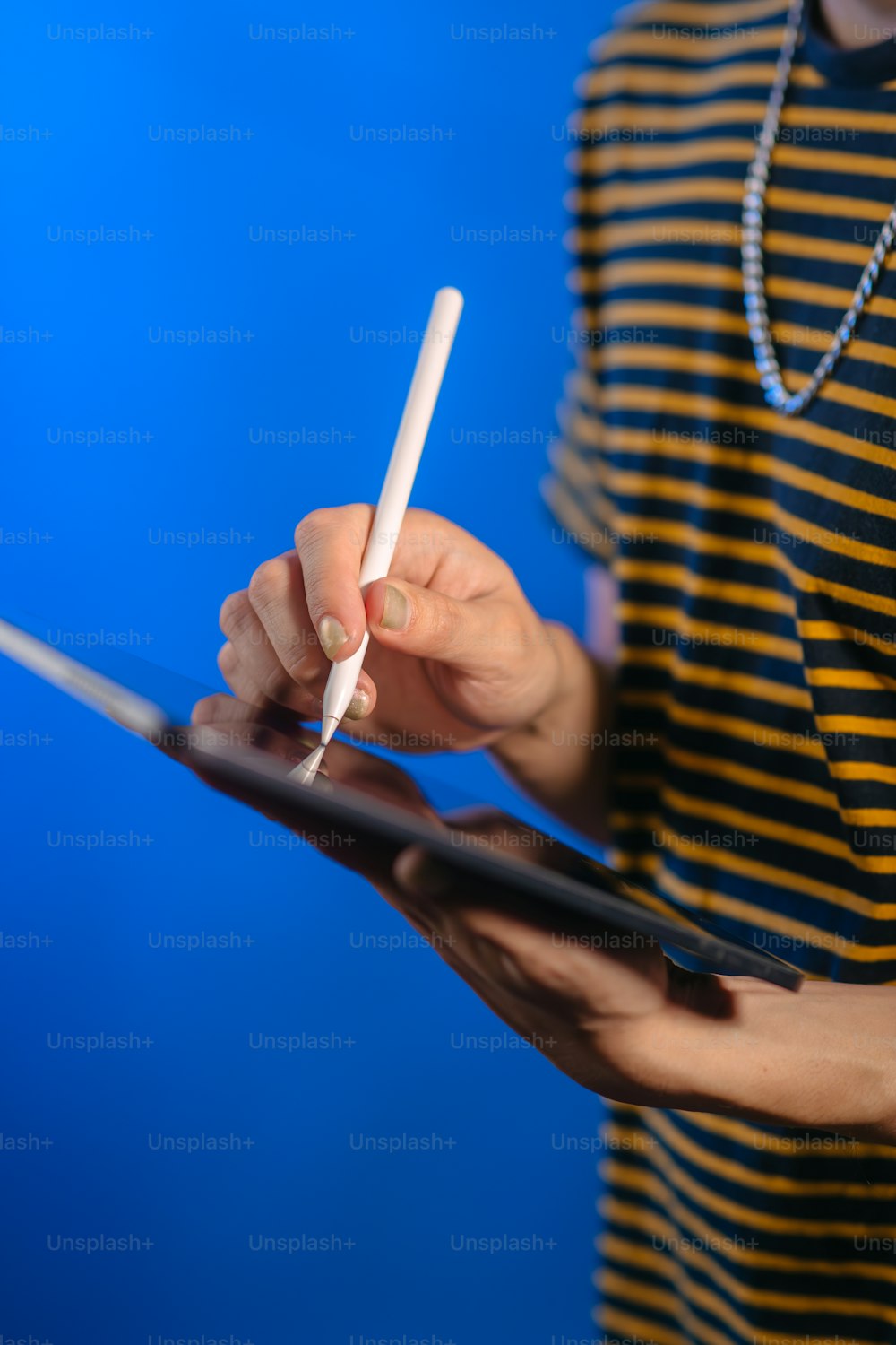 eine Person, die ein Tablet mit einem Stift in der Hand hält